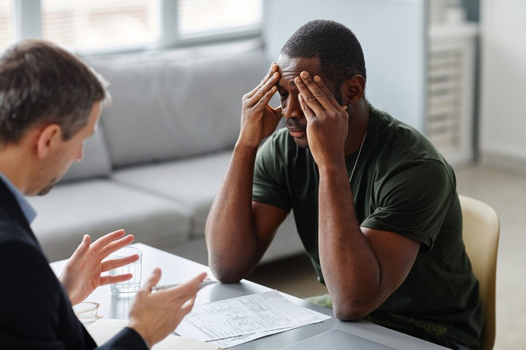 man speaking with his therapist getting help with PTSD and Addiction