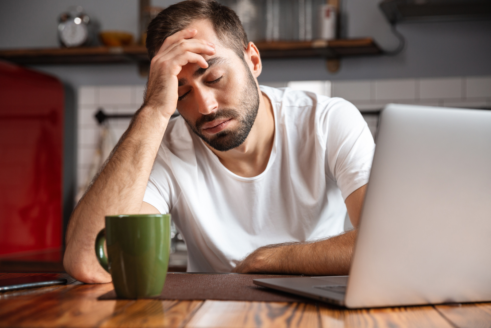 man sitting at table by laptop looking up Can Withdrawal Kill You?